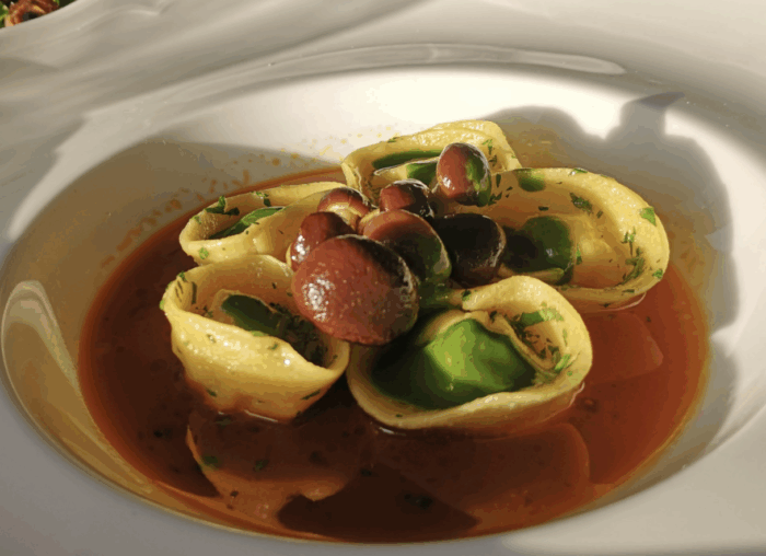 Ravioli in guazzetto di minestra di pesce con ripieno di scorfano a coltello, funghi pioppini e olio all’aneto